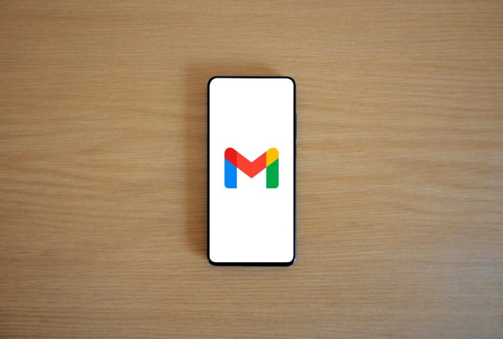 Smartfon z logo Gmaila na drewnianym blacie